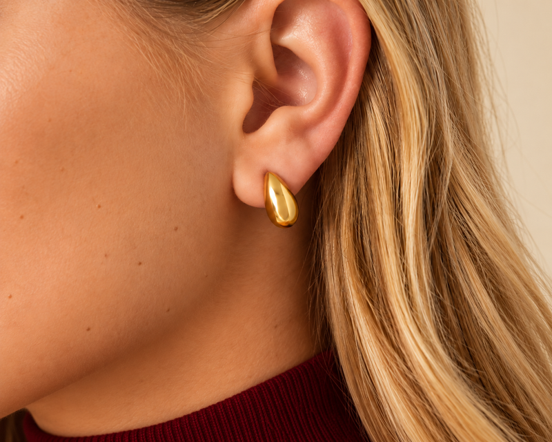Minimalistische gouden oorknopjes gedragen door een vrouw – Pamora