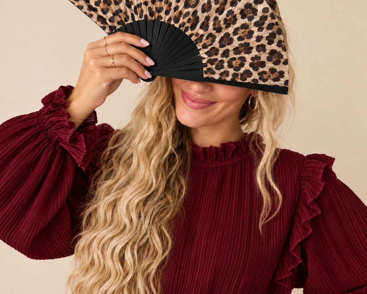 Vrouw met stijlvolle accessoires in warme bordeauxrode en beige tinten.